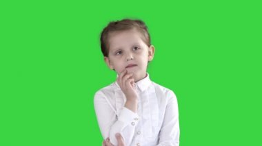 Meraklı bir küçük kız duruyor ve Yeşil Ekran, Chroma Key düşünüyor.