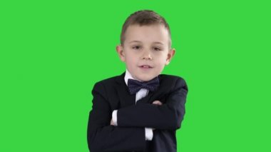 Küçük çocuk çocuk yeşil ekran üzerinde resmi bir kostüm el geçiş, chroma key.