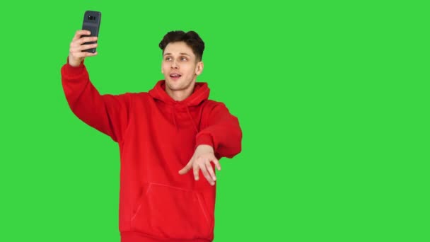 Возбужденный случайный мужчина танцует и делает селфи со своим телефоном на зеленом экране, Chroma Key. — стоковое видео