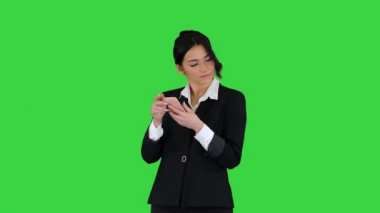 Genç iş kadını telefonda müzik dinliyor ve yeşil ekranda dans ediyor, Chroma Key..