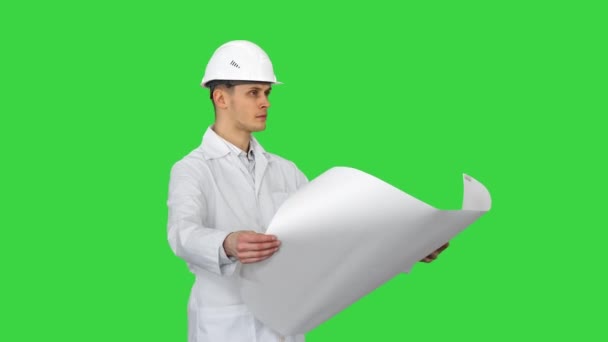 Ingeniero guapo, arquitecto, constructor, empresario, con un casco blanco sosteniendo un proyecto en su mano, mirando el objeto y bailando en una pantalla verde, Chroma Key. — Vídeos de Stock