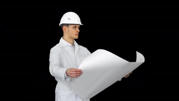 Handsome engineer, architect, builder, businessman, wearing a white helmet holding a project in his hand, looking at the object and dancing, Alpha Channel — Stock Video