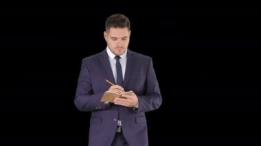 Alpha Channel 'da yürürken fikirlerini deftere yazan yakışıklı bir menajer.