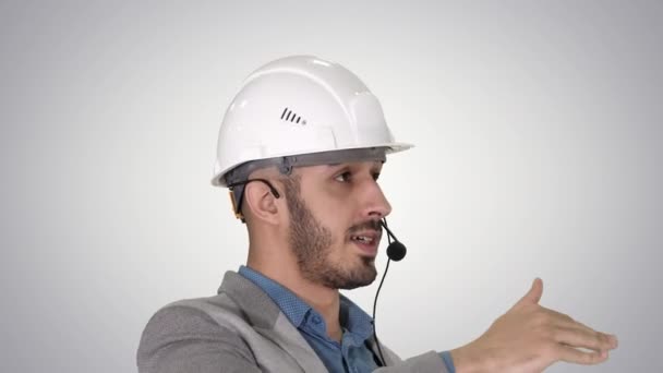 Architect inspecteert werk van kraan praten via Head Set, op gradiënt achtergrond. — Stockvideo