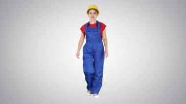 Sarı şapkalı genç bir kadın değişken arka planda yürüyor..