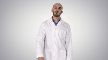 Dost erkek doktor yürüyüş ve degrade arka planda kamera bakarak konuşuyor.