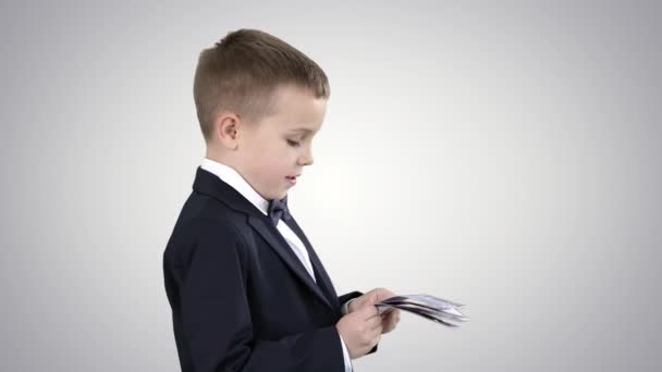 Niño en traje negro cuenta el dinero en el fondo del gradiente. — Vídeos de Stock