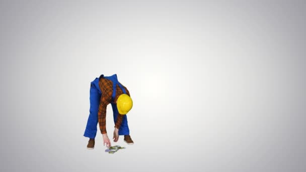 建設労働者は、グラデーションの背景に床からユーロを拾う. — ストック動画