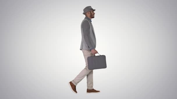 Muž v ležérní chůze s kufříkem na gradient pozadí. — Stock video