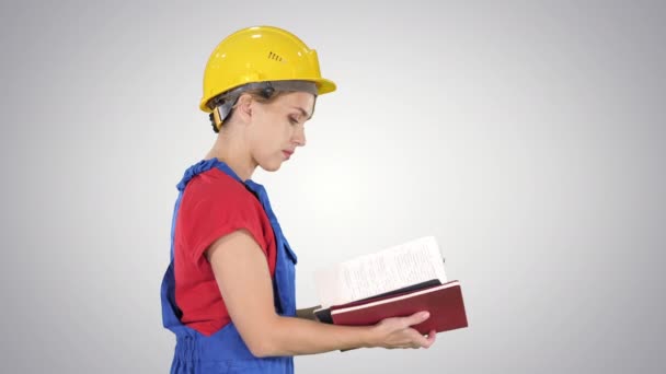 Női építőmunkás kemény kalapban és munkaruha egyenruhában ellenőrzi a listát gradiens háttér. — Stock videók