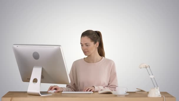 Красивая женщина работает за компьютером на градиентном фоне. — стоковое видео