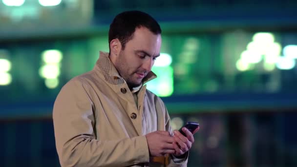 Schöner erwachsener Mann, der eine SMS sendet, während er auf der Straße der Stadt steht, Geschäftsmann, der Nachrichten liest. — Stockvideo