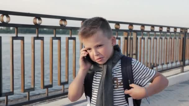 Kleine Kid Boy Walking Home met rugzak en praten aan de telefoon met ouders. — Stockvideo