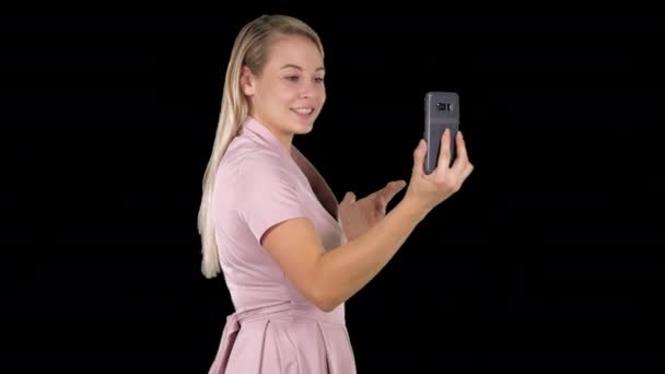 Mujer en vestido rosa haciendo videollamada con su teléfono inteligente, Alpha Channel — Vídeos de Stock