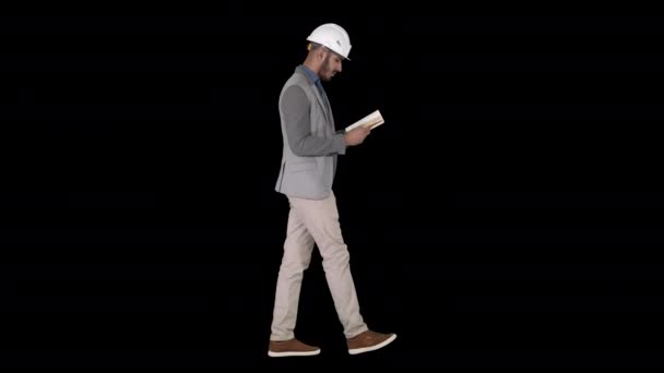 Νέος αρχιτέκτονας διαβάζει βιβλίο ή σημειωματάριο, ενώ περπατάει, κανάλι άλφα — Αρχείο Βίντεο