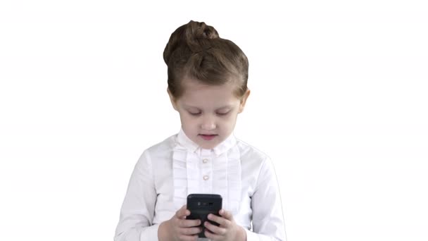 Roztomilá holčička vypadá jako smartphone a píše zprávu na bílém pozadí.. — Stock video