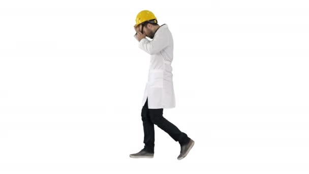 Νέος φοιτητής μηχανικών κατασκευών περπάτημα και βάζοντας το καπάκι στο λευκό φόντο. — Αρχείο Βίντεο