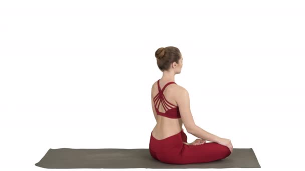 Femme sportive pratiquant la pose de lotus de yoga, se tournant vers la caméra et souriant sur fond blanc . — Video