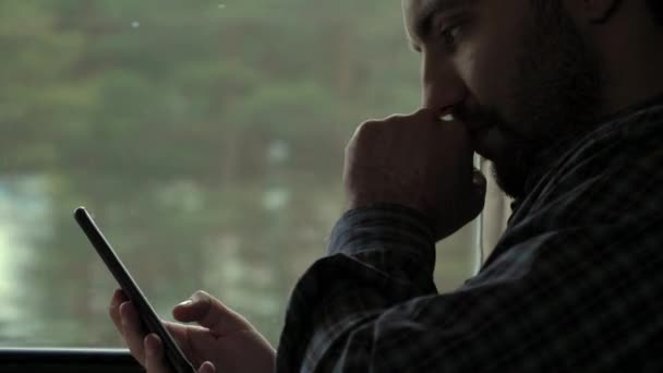 Young concentrated man making money transaction via application on mobile phone in a train. — Stock Video