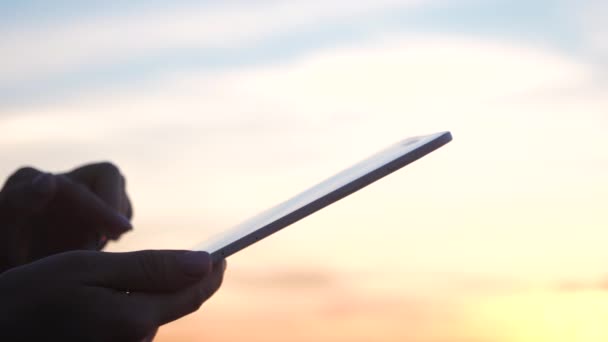 Femme mains tenant tablette numérique pc et toucher avec le doigt dans la lumière du soleil . — Video