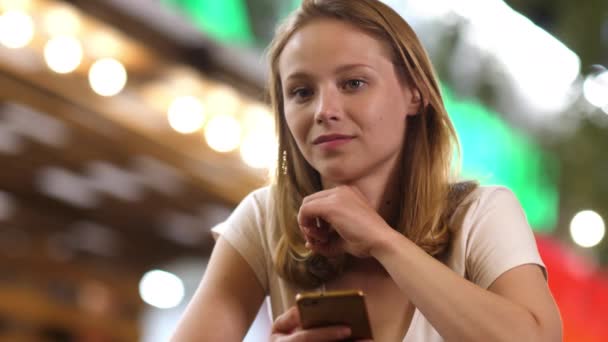 Gespannen tiener meisje kijken naar camera houden van een telefoon in haar hand. — Stockvideo