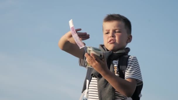 Jongen gooit geld in de lucht. — Stockvideo