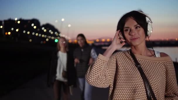 Joven morena escuchando música con auriculares y sonriendo . — Vídeos de Stock