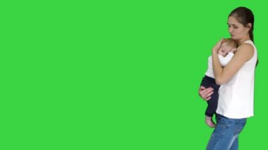 Genç Anne çalışıyor için sakin aşağı çocuk oğul üzerinde bir yeşil ekran, chroma key.