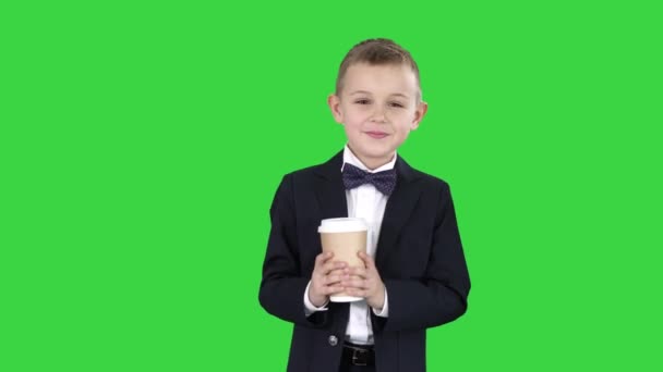 グリーンスクリーン、クロマキーのフォーマルな服を着てコーヒーを持って歩く少年. — ストック動画