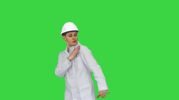 Забавный сайентист в белом халате и шлеме безопасности, танцующий на зеленом экране, Chroma Key. — стоковое видео