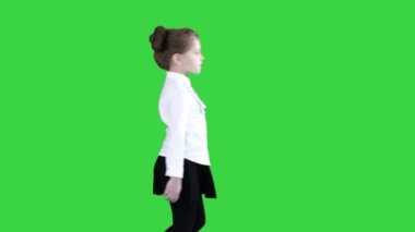 Yeşil Ekranda yürüyen okul üniformalı küçük kız, Chroma Key.