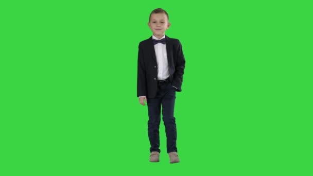 Pojke i formella kostym promenader med en hand i fickan på en grön skärm, Chroma Key. — Stockvideo
