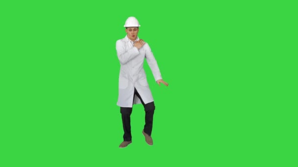 Funny scientinst in white robe and safety helmet dancing on a Green Screen, Chroma Key. — Stock Video