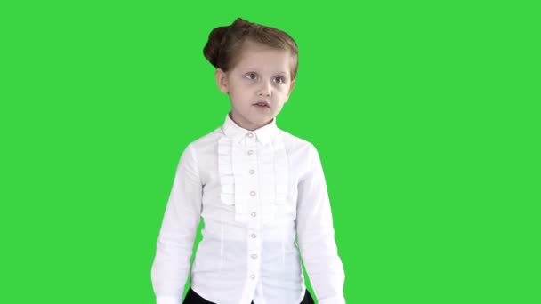 School meisje wandelen en praten met camera op een groen scherm, Chroma Key. — Stockvideo