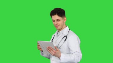 Çekici kendine güvenen doktor yeşil ekrandaki sonuçları okuduktan sonra tabletle dans ediyor, Chroma Key.
