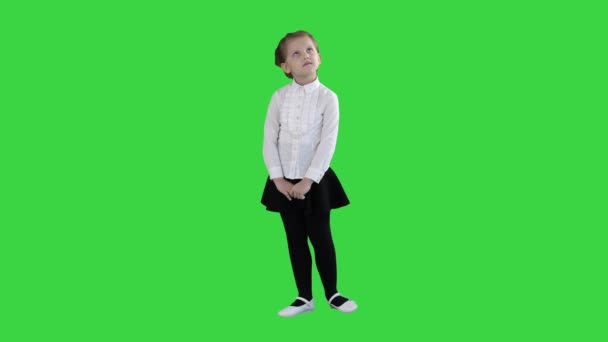 Aranyos óvodai lány állt, hogy félénk nézett körül, és gondolkodás egy zöld képernyő, chroma key. — Stock videók