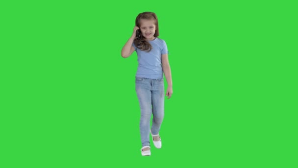 Yeşil Ekranda yürürken küçük sevimli kız bir telefon görüşmesi yapma, Chroma Anahtar. — Stok video