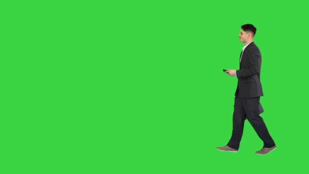 Счастливый успешный бизнесмен танцует, слушая музыку из телефона и прогуливаясь по зеленому экрану, хромированный ключ. — стоковое видео