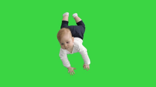 Солодкі дитини прокладки і тримаючи голову на зеленому екрані, ключ кольоровості. — стокове відео