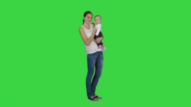 Sevimli bebek oğlan içinde anneler eller seyir için kamera üzerinde bir yeşil ekran, Chroma anahtar.