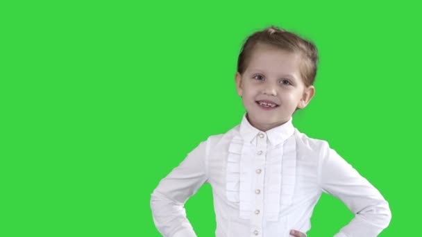Μικρό κορίτσι που ποζάρει σε διαφορετικές ποζάρει σε μια πράσινη οθόνη, πλήκτρο αποχρώσεων. — Αρχείο Βίντεο