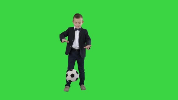 Fiú hivatalos öltöny rúgás futball egy zöld képernyő, chroma key. — Stock videók