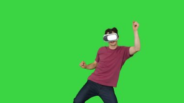 Gelişmiş oyuncu günlük kıyafetleriyle VG kulaklıkla dans oyunu oynuyor. Yeşil ekran, Chroma Key 'de..