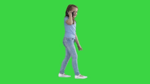 Маленька дівчинка розмова телефон і ходьба на зеленому екрані, ключ кольоровості. — стокове відео