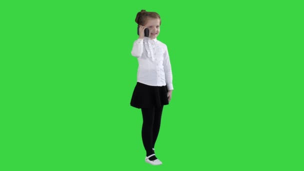 Mooi klein meisje, praten op de telefoon op een groen scherm, Chroma Key. — Stockvideo
