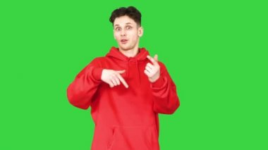 Yeşil ekranda kameraya hikaye anlatan yakışıklı genç adam, Chroma Key..