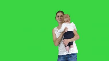 Mutlu anne ve sevimli çocuk bebek oğlu el sallayarak el sallayarak yeşil ekranda kameraya merhaba diyerek, Chroma Key.