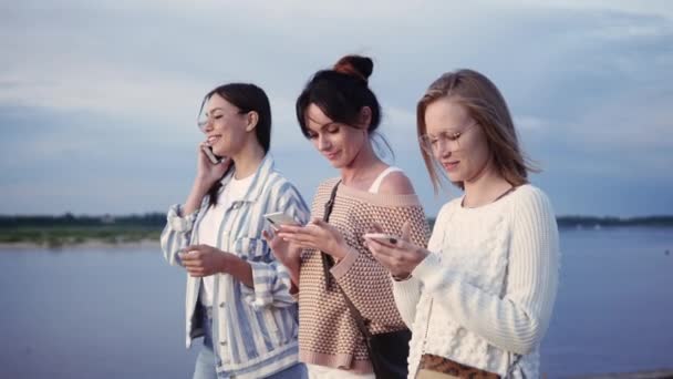Gadis-gadis modern berjalan menggunakan ponsel mereka. Pecandu perangkat. — Stok Video