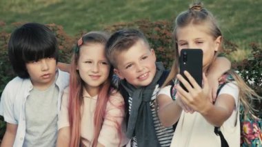 Güzel okul çocukları arkadaşlar akıllı telefonda selfie çekiyor.