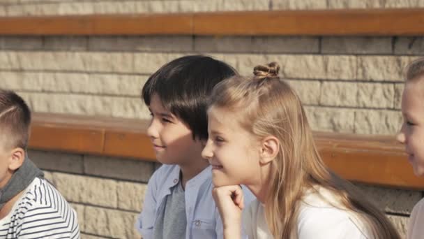 Schattige jongen en meisje zitten in het Park. — Stockvideo